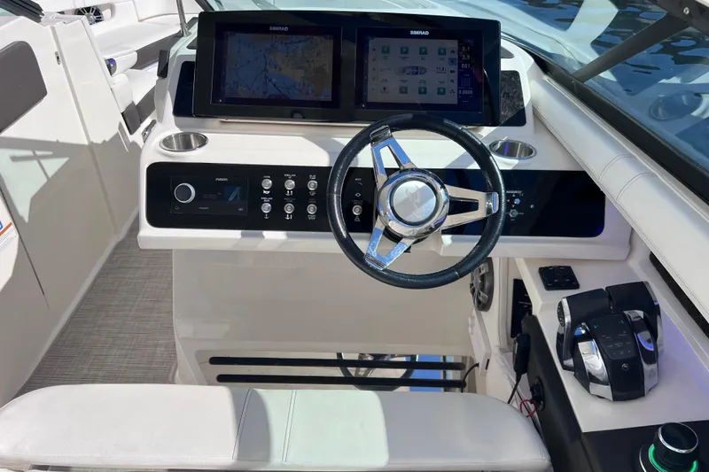 Slide: The Image of 2019 Sea Ray SLX 310 Outboard helm with dual displays and modern controls. - 43