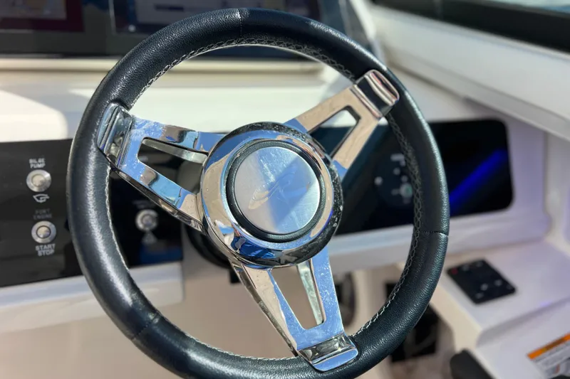 Slide: The Image of 2019 Sea Ray SLX 310 Outboard boat with polished metal details under clear blue sky. - 48