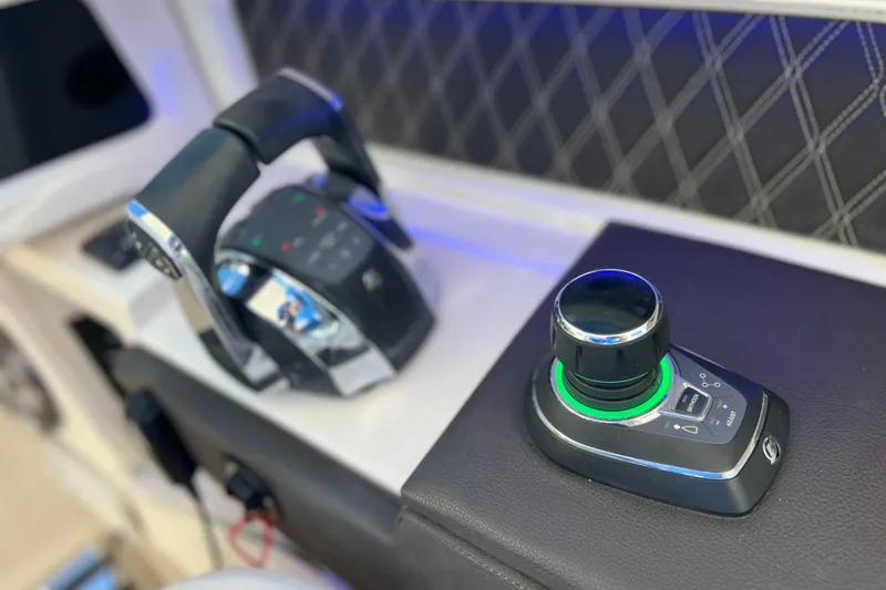 Slide: The Image of Steering wheel of 2019 Sea Ray SLX 310 Outboard boat, featuring sleek design and controls. - 49