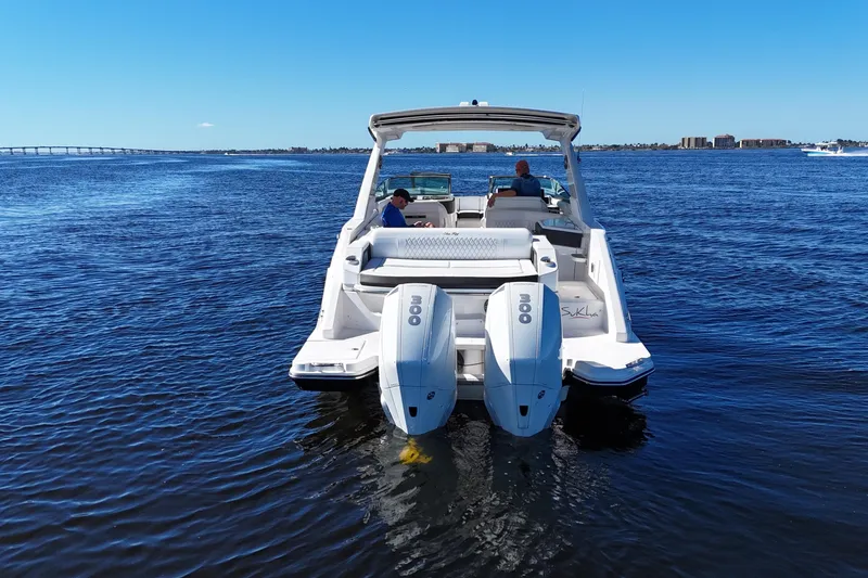 Slide: The Image of 2019 Sea Ray SLX 310 Outboard cruising on a sunny day with clear blue skies. - 5