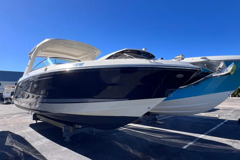 Slide: The Image of 2019 Sea Ray SLX 310 Outboard with dual Mercury engines, docked under clear blue sky. - 86
