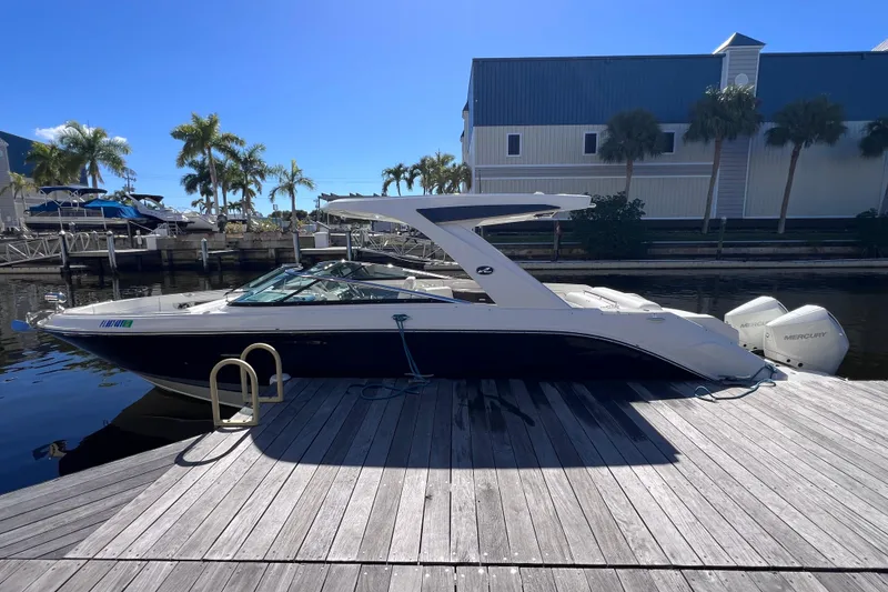 Slide: The Image of 2019 Sea Ray SLX 310 Outboard boat docked by a waterfront building. - 9
