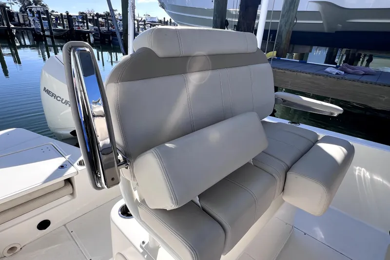 Slide: The Image of 2023 Boston Whaler 220 Dauntless boat with Mercury engine, docked on calm water. - 18