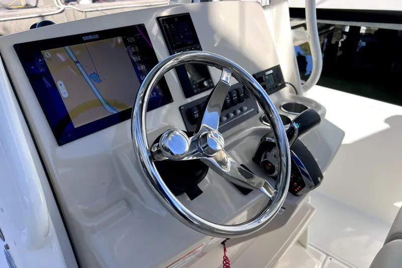 Slide: The Image of Hand holding a hose spraying water near a docked Boston Whaler 220 Dauntless, 2023 model. - 21