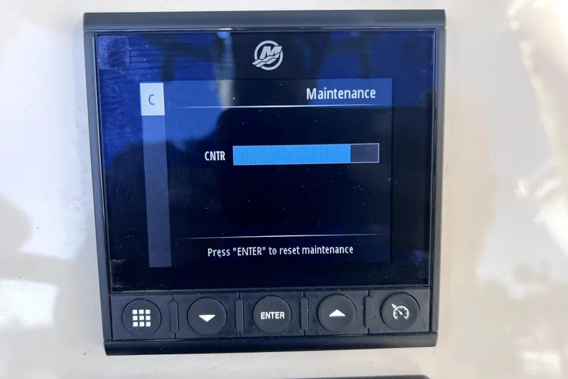 Slide: The Image of 2023 Boston Whaler 220 Dauntless boat interior with cushioned seating and Mercury engine. - 28