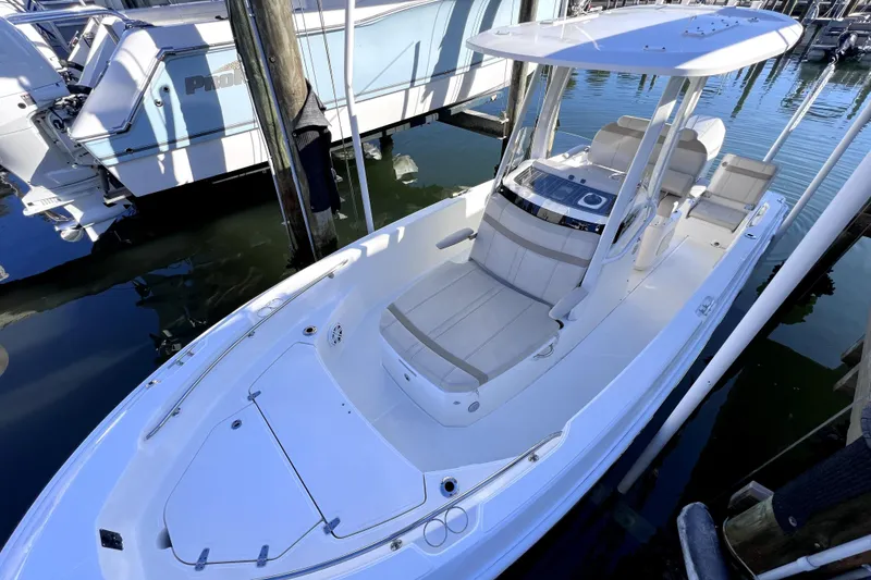 Slide: The Image of 2023 Boston Whaler 220 Dauntless boat cruising on a calm waterway under clear blue skies. - 3
