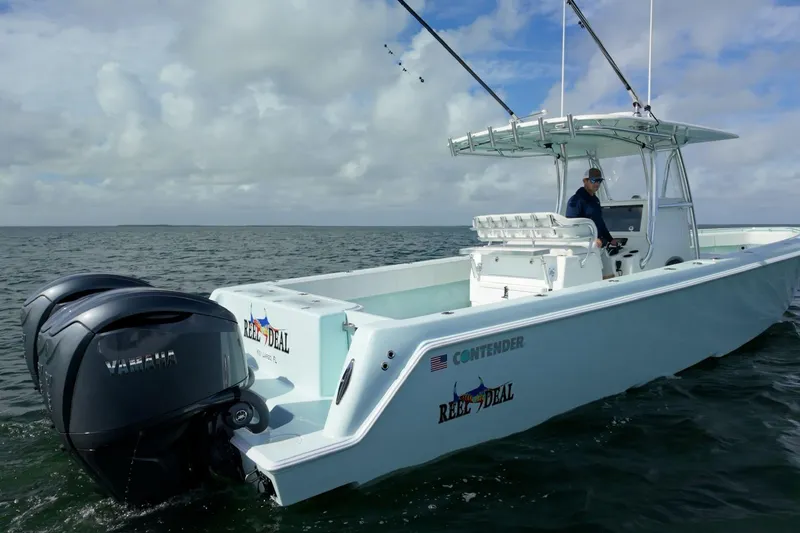 The Image of 2025 Contender 39 ST boat on water, featuring dual Yamaha engines, under cloudy sky. - 0