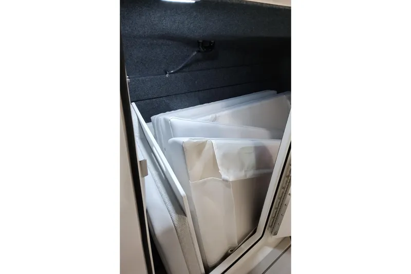 Slide: The Image of Storage compartment in 2026 Formula 360 Crossover Bowrider OB, featuring neatly stacked cushions. - 21