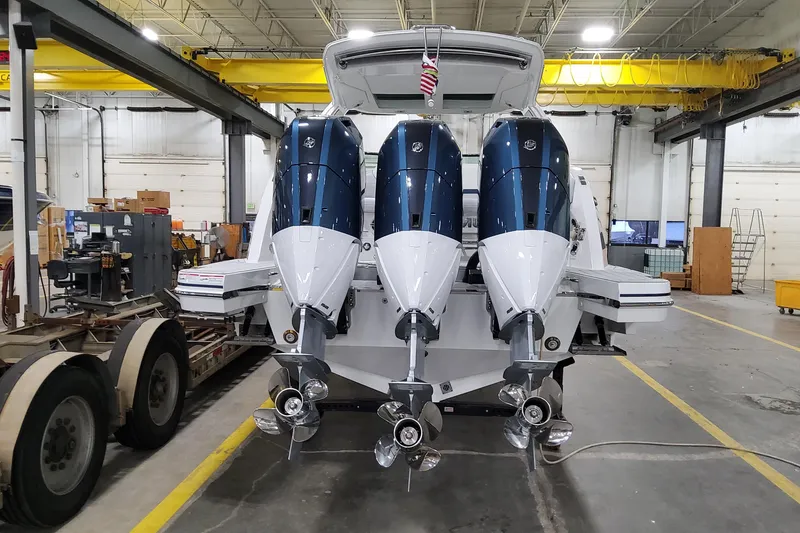 Slide: The Image of 2026 Formula 360 Crossover Bowrider OB with triple outboard engines in a workshop. - 6