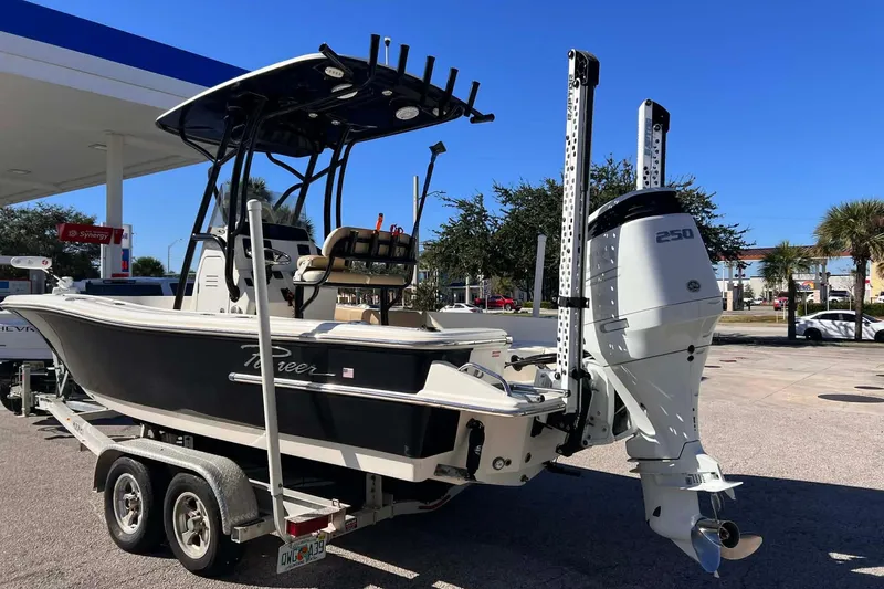The Image of 2022 Pioneer 220 Bay Sport boat on trailer at a gas station. - 1