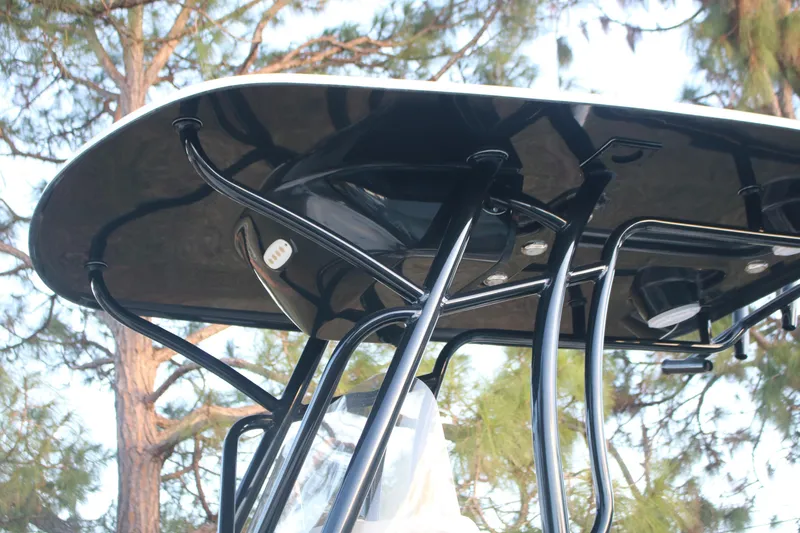 Slide: The Image of T-top of 2022 Pioneer 220 Bay Sport boat with trees in background. - 10