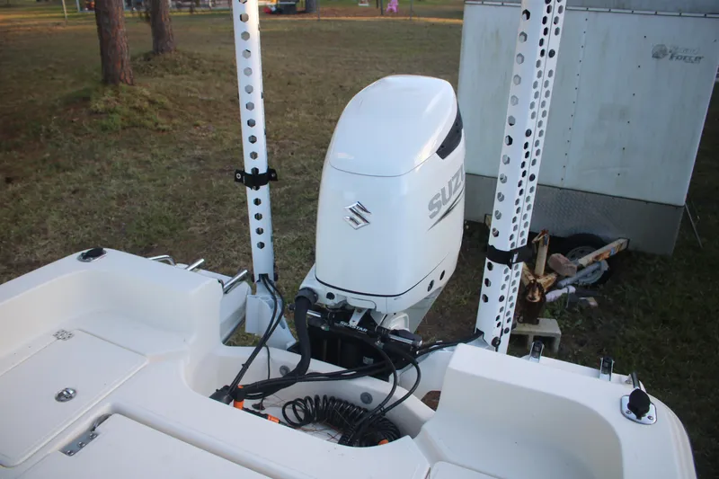 Slide: The Image of 2022 Pioneer 220 Bay Sport boat with Suzuki outboard motor in a grassy area. - 19