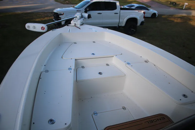 Slide: The Image of 2022 Pioneer 220 Bay Sport boat deck with storage compartments and trolling motor. - 22