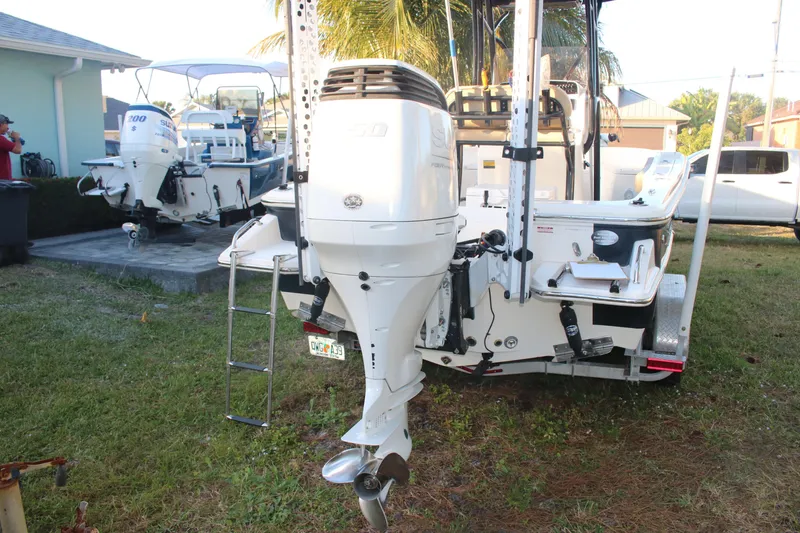 Slide: The Image of 2022 Pioneer 220 Bay Sport boat with outboard motor, parked on grass. - 7