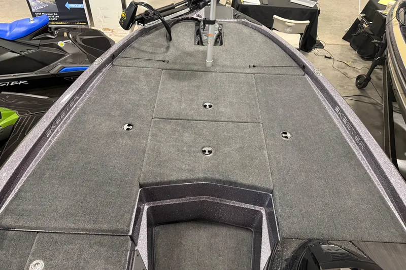 Slide: The Image of 2024 Skeeter ZX150 boat deck with carpeted surface and storage compartments. - 7