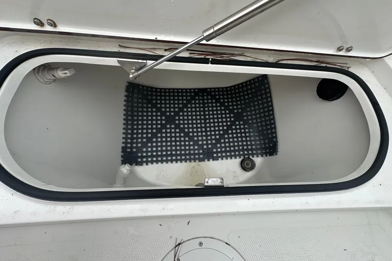 Slide: The Image of Open storage compartment in 2022 BlackJack 256 Bay boat with black mat inside. - 16