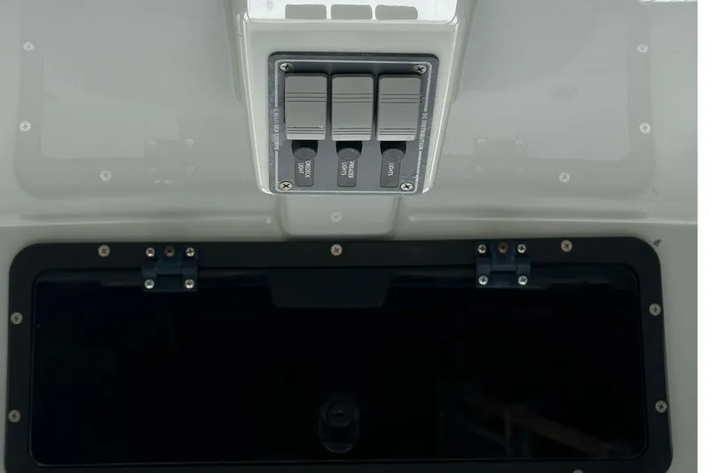 Slide: The Image of Control panel on a 2022 BlackJack 256 Bay boat, featuring labeled switches. - 18