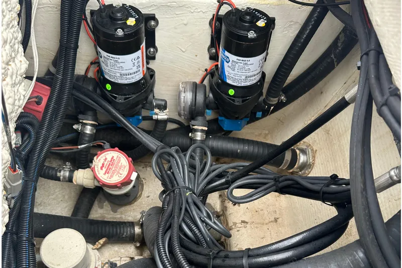 Slide: The Image of 2022 BlackJack 256 Bay boat wiring and pump system in the engine compartment. - 7