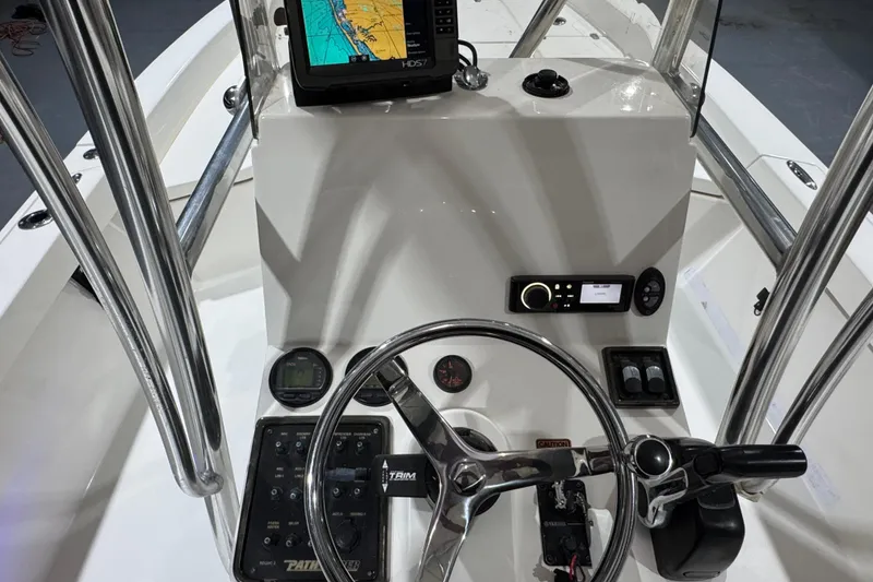Slide: The Image of 2013 Pathfinder 2400 V boat console with steering wheel, navigation system, and controls. - 13