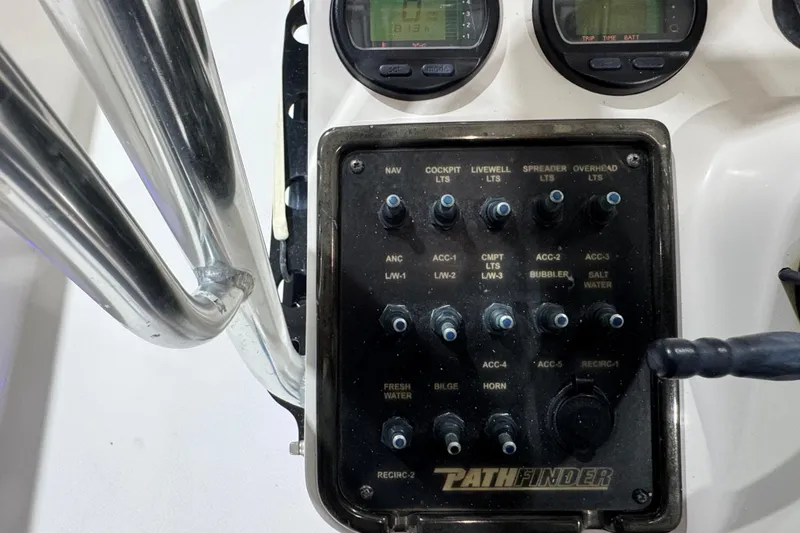 Slide: The Image of Control panel of a 2013 Pathfinder 2400 V boat with various switches and gauges. - 16