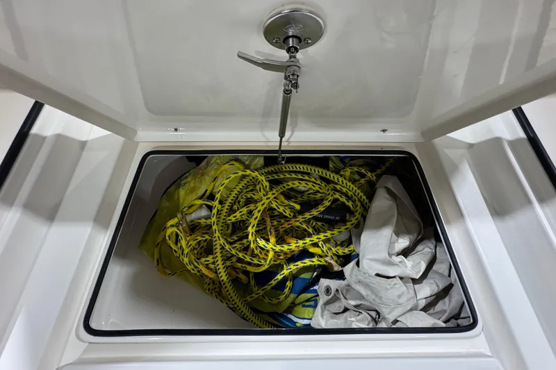 Slide: The Image of Open storage compartment on 2013 Pathfinder 2400 V boat with ropes and fabric inside. - 27