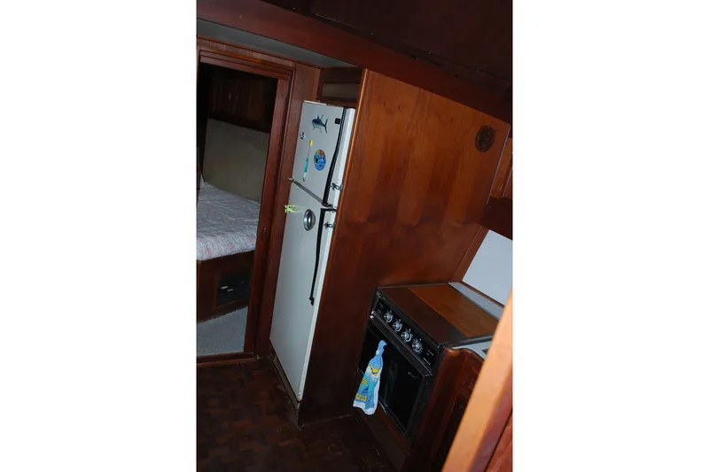 Slide: The Image of Interior of 1987 Jersey Dawn boat with wood paneling, kitchen appliances, and cozy sleeping area. - 17