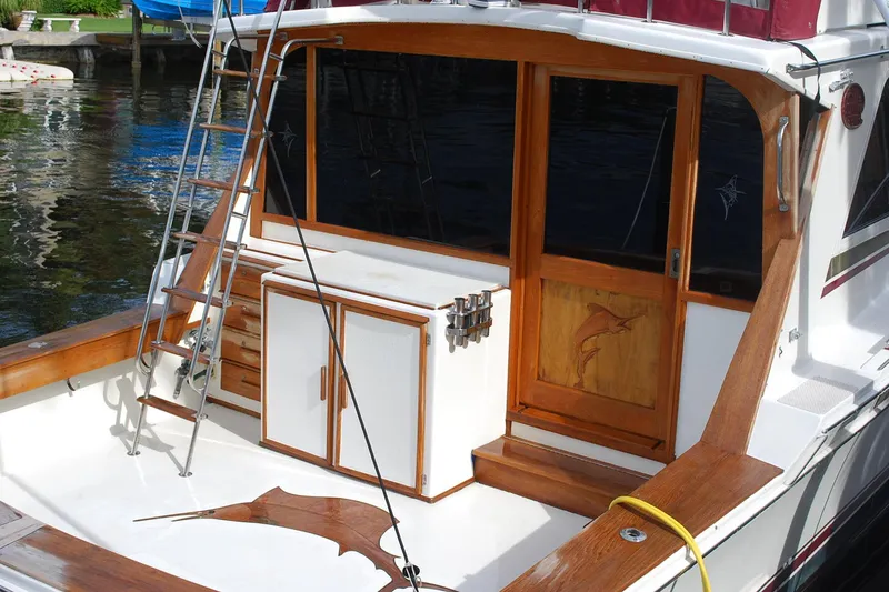 Slide: The Image of 1987 Jersey Dawn boat deck with wooden accents and fishing rod holders. - 2