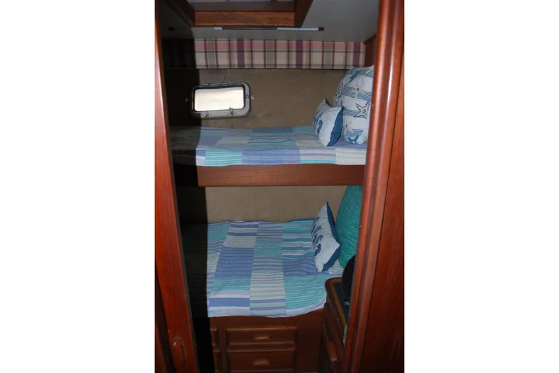 Slide: The Image of Cozy bunk beds in 1987 Jersey Dawn boat cabin with nautical-themed bedding. - 21