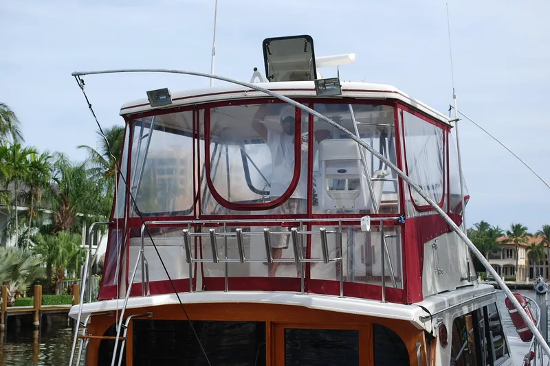 Slide: The Image of 1987 Jersey Dawn boat with red canopy, docked near palm trees and waterfront homes. - 4