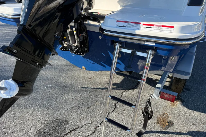 Slide: The Image of Bayliner Trophy T22CC 2026 boat with ladder and outboard motor on a trailer. - 4