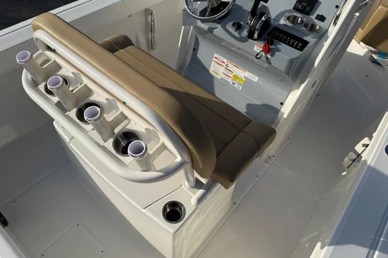 Slide: The Image of 2026 Bayliner Trophy T22CC boat interior with rod holders and helm controls. - 9