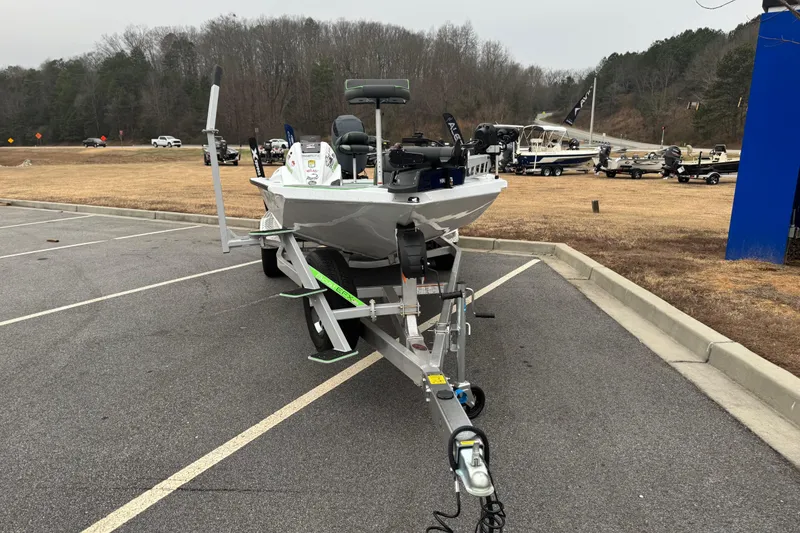 Slide: The Image of 2026 Xpress H20 Bass boat on trailer in parking lot, surrounded by trees. - 4