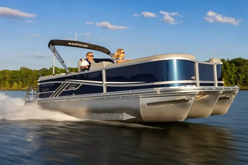 Slide: The Image of Manufacturer Provided Image: 2026 SunCatcher Fusion 324RC pontoon boat cruising on a lake under a clear blue sky. - 11