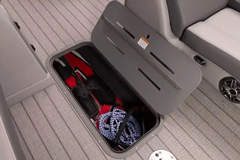 Slide: The Image of Manufacturer Provided Image: Open storage compartment on 2026 SunCatcher Fusion 324RC boat, containing life jackets and rope. - 14