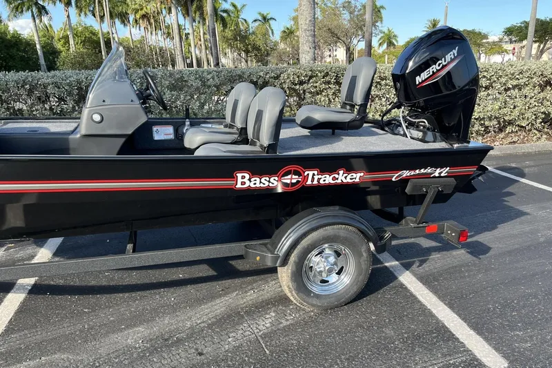Slide: The Image of 2026 Tracker Bass Tracker Classic XL boat with Mercury engine in a parking lot. - 5