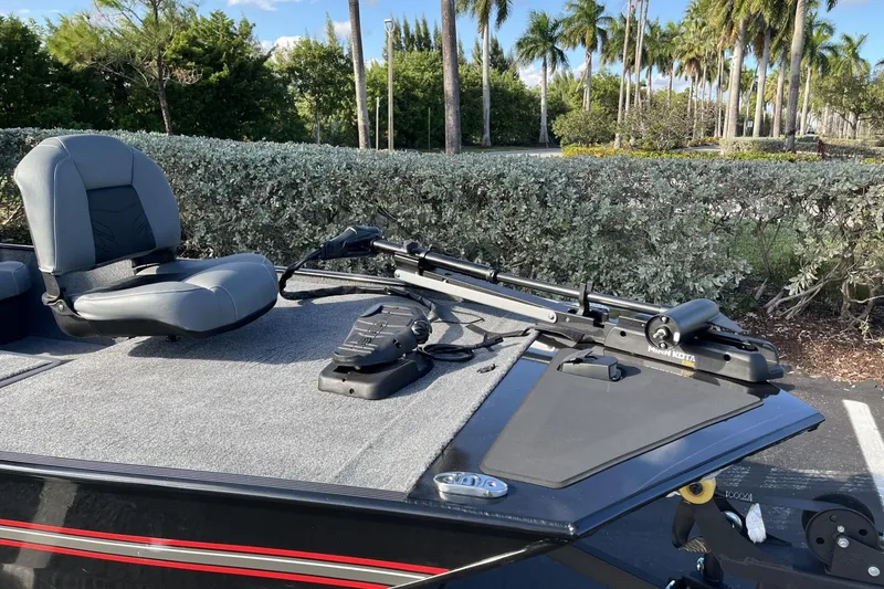 Slide: The Image of 2026 Tracker Bass Tracker Classic XL boat with seating and trolling motor, surrounded by lush greenery. - 9