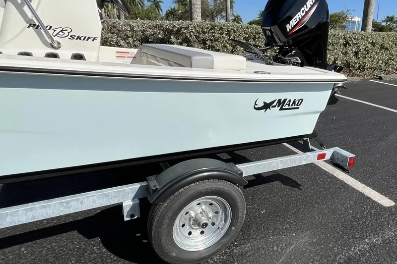 Slide: The Image of 2026 Mako Pro Skiff 13 CC boat on trailer, featuring Mercury outboard motor. - 52
