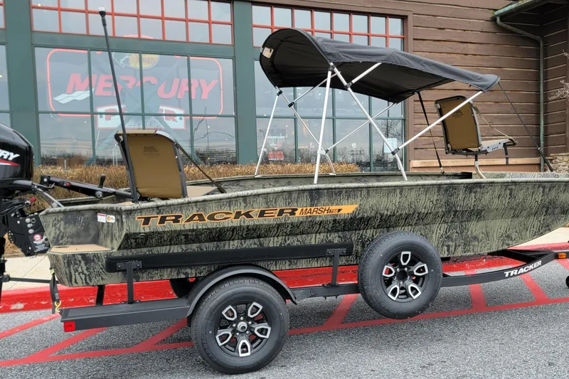 The Image of 2026 Tracker Grizzly 1756 T Marsh boat on trailer, parked outside a store. - 0