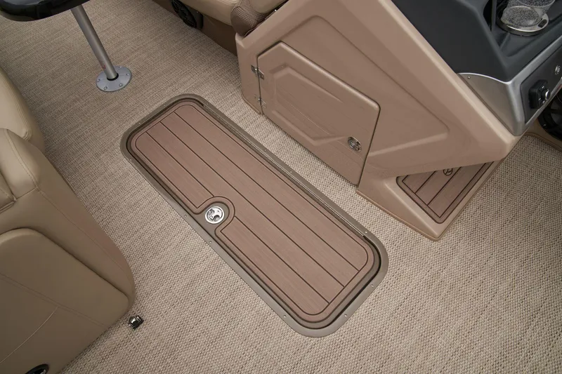 Slide: The Image of 2025 Regency 230 LE3 boat interior storage compartment with open lid and carpeted flooring. - 16