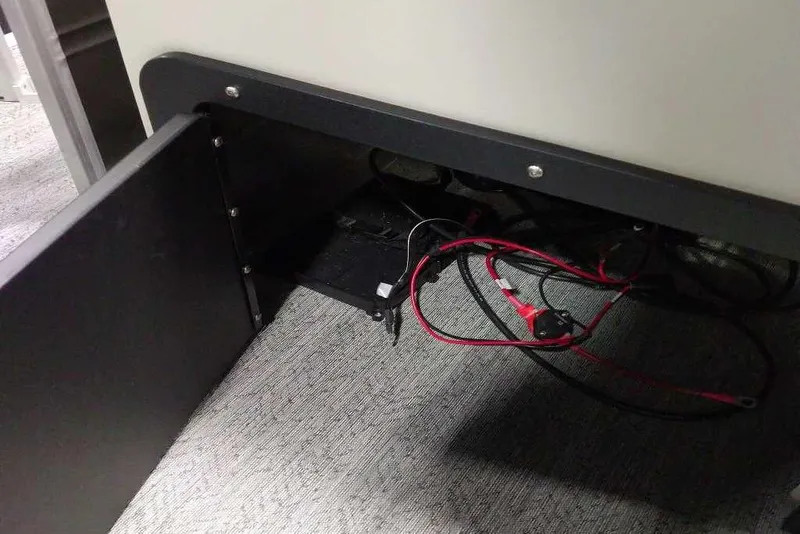 Slide: The Image of Open compartment with wiring inside Sun Tracker Fishin' Barge 22 XP3, 2026 model. - 113