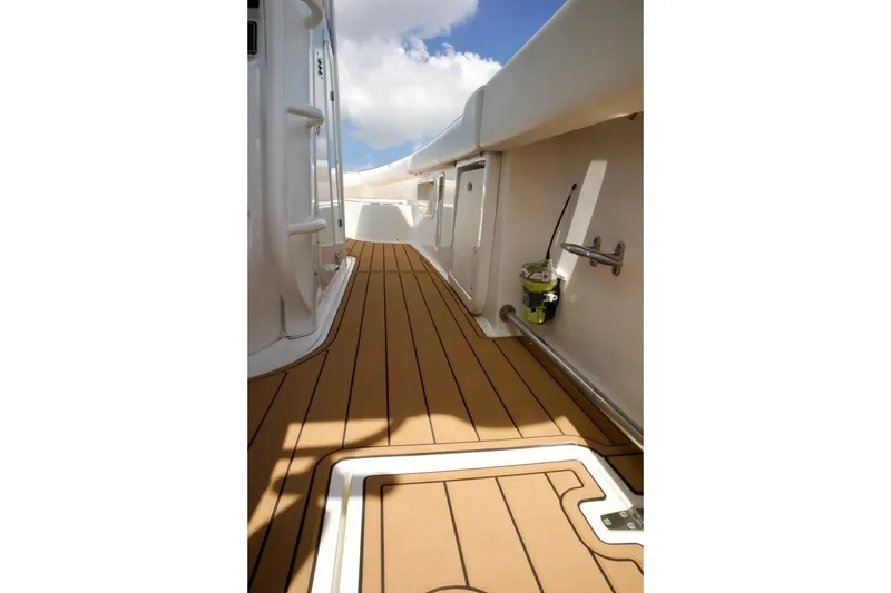 Slide: The Image of 2013 Boston Whaler 320 Outrage boat deck with teak flooring and clear sky. - 11