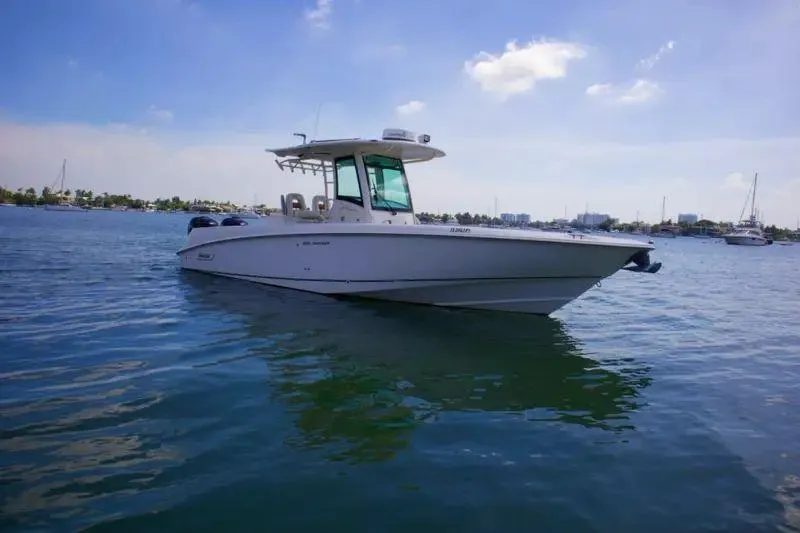 Slide: The Image of 2013 Boston Whaler 320 Outrage boat on calm water under blue sky. - 3