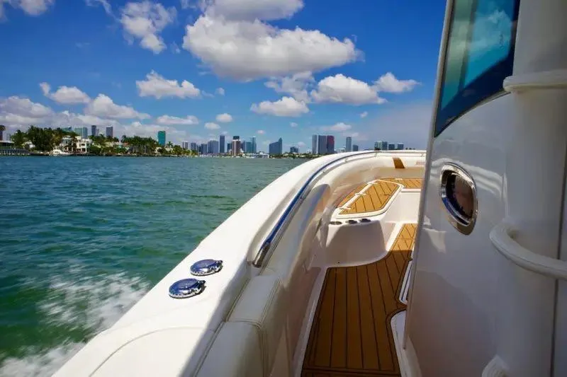 Slide: The Image of 2013 Boston Whaler 320 Outrage cruising near city skyline under blue sky. - 8