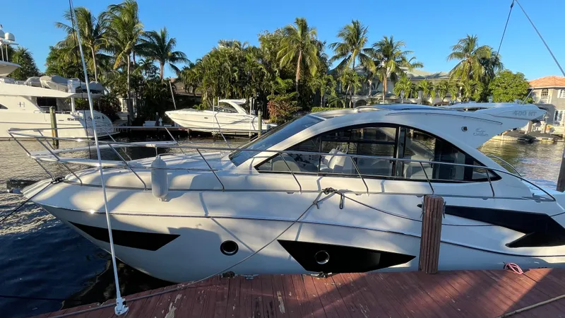 Slide: The Image of 2022 Evolve 400HT yacht docked by palm trees and waterfront homes. - 5