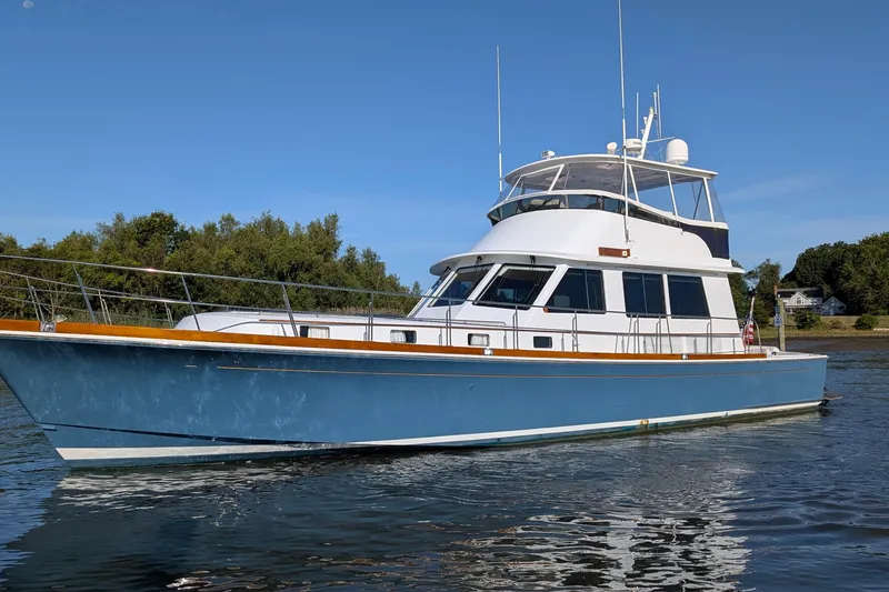 Slide: The Image of 2004 Grandbanks 58 Eastbay FB yacht on calm water, clear sky background. - 2
