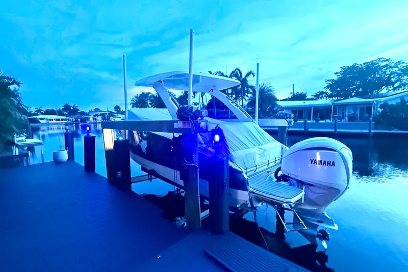 Slide: The Image of 2023 Regal LX6 boat docked at a serene waterfront with Yamaha engine. - 1