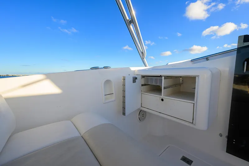 Slide: The Image of Interior of 1998 Aura 28 Tournament Series boat with storage compartments under a clear blue sky. - 13