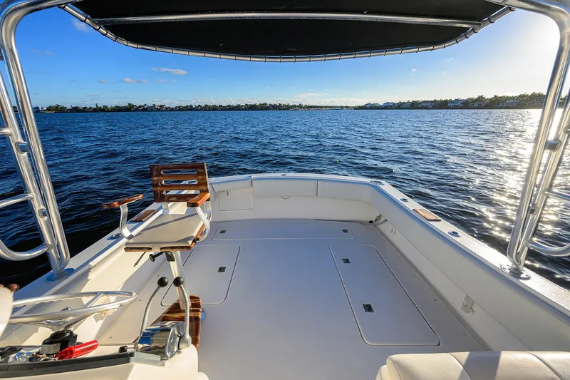 Slide: The Image of 1998 Aura 28 Tournament Series boat on calm water, featuring spacious deck and fishing chair. - 18