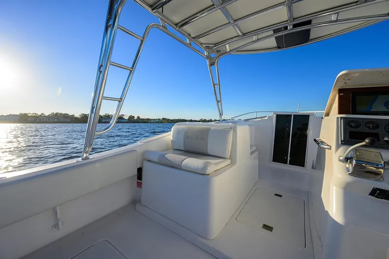 Slide: The Image of 1998 Aura 28 Tournament Series boat interior with seating and steering, on a sunny day. - 30