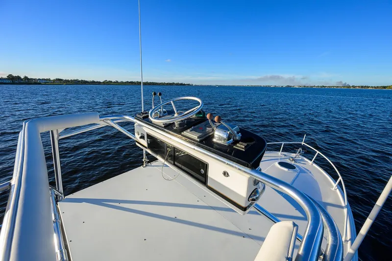 Slide: The Image of Helm of 1998 Aura 28 Tournament Series boat on open water under clear blue sky. - 33